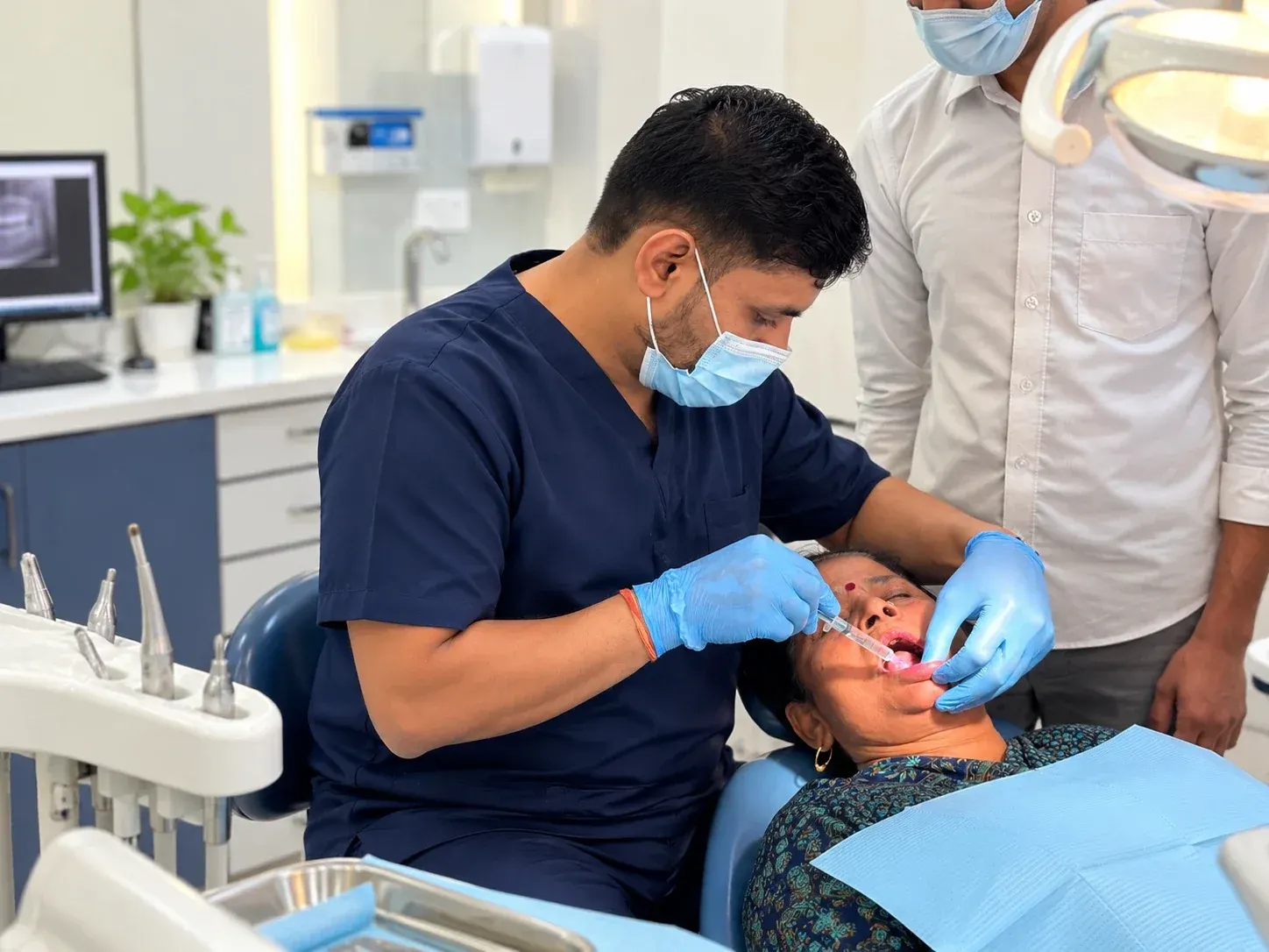A Roots & Pulp dentist carrying out treatment for a patient in the dental chair